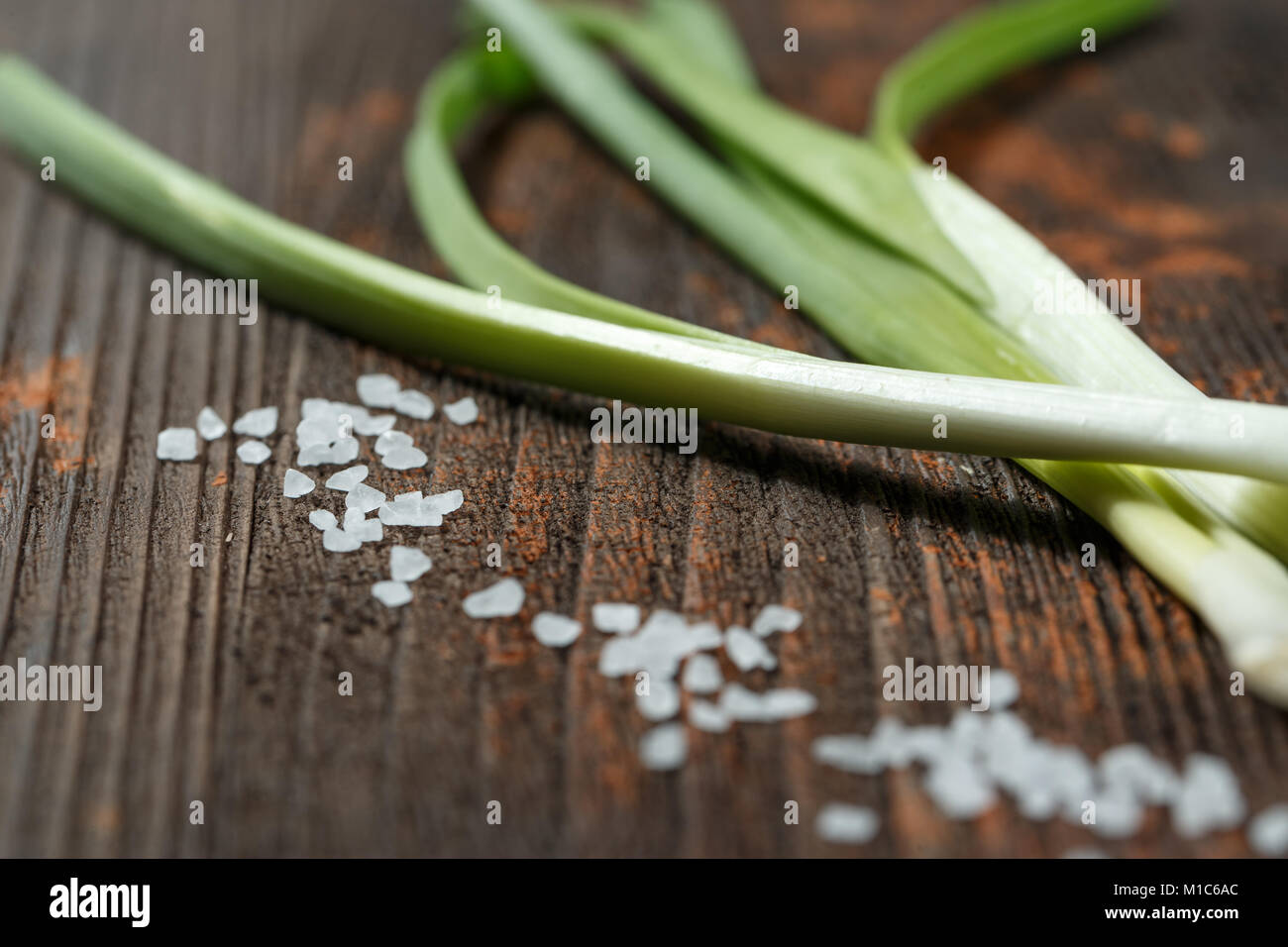Il sale di mare e di un giovane di grani di cipolla su sfondo nero. Foto Stock