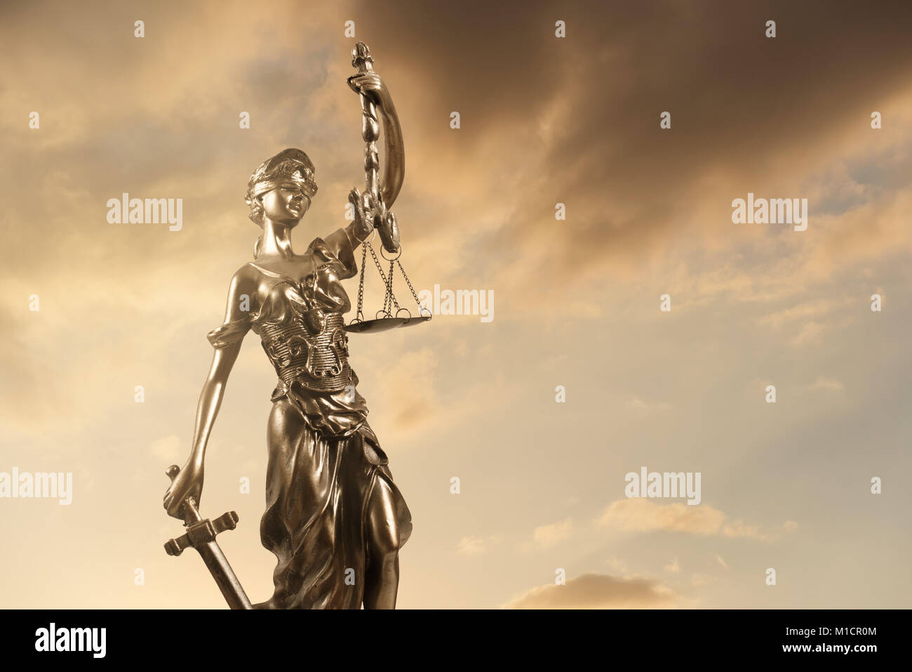 Statua della giustizia contro NUVOLOSO TRAMONTO. Foto Stock