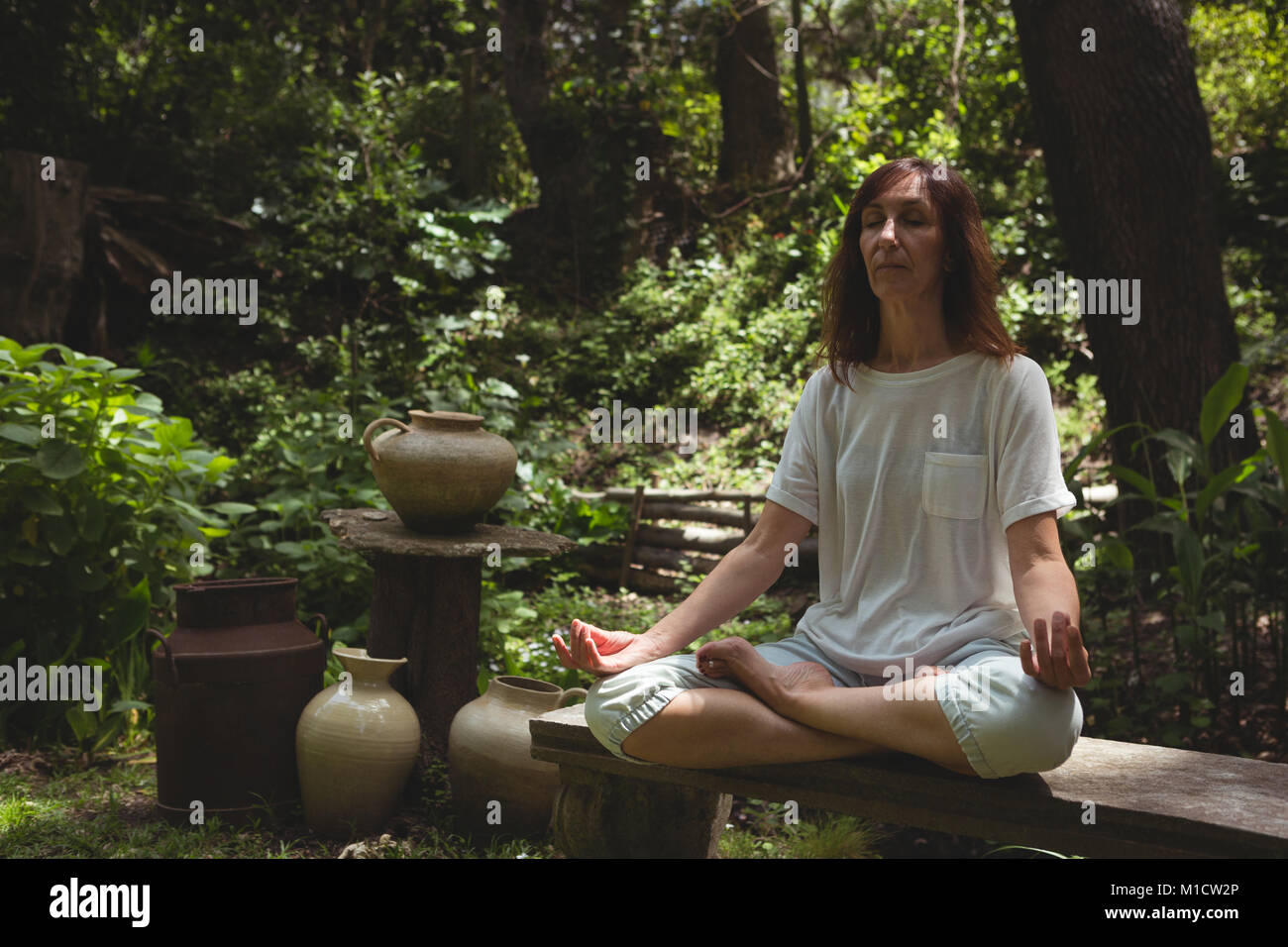 La donna a praticare yoga in giardino Foto Stock