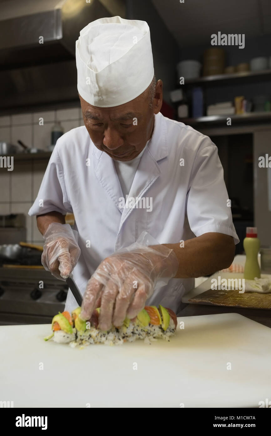 Senior chef prepara sushi in cucina Foto Stock
