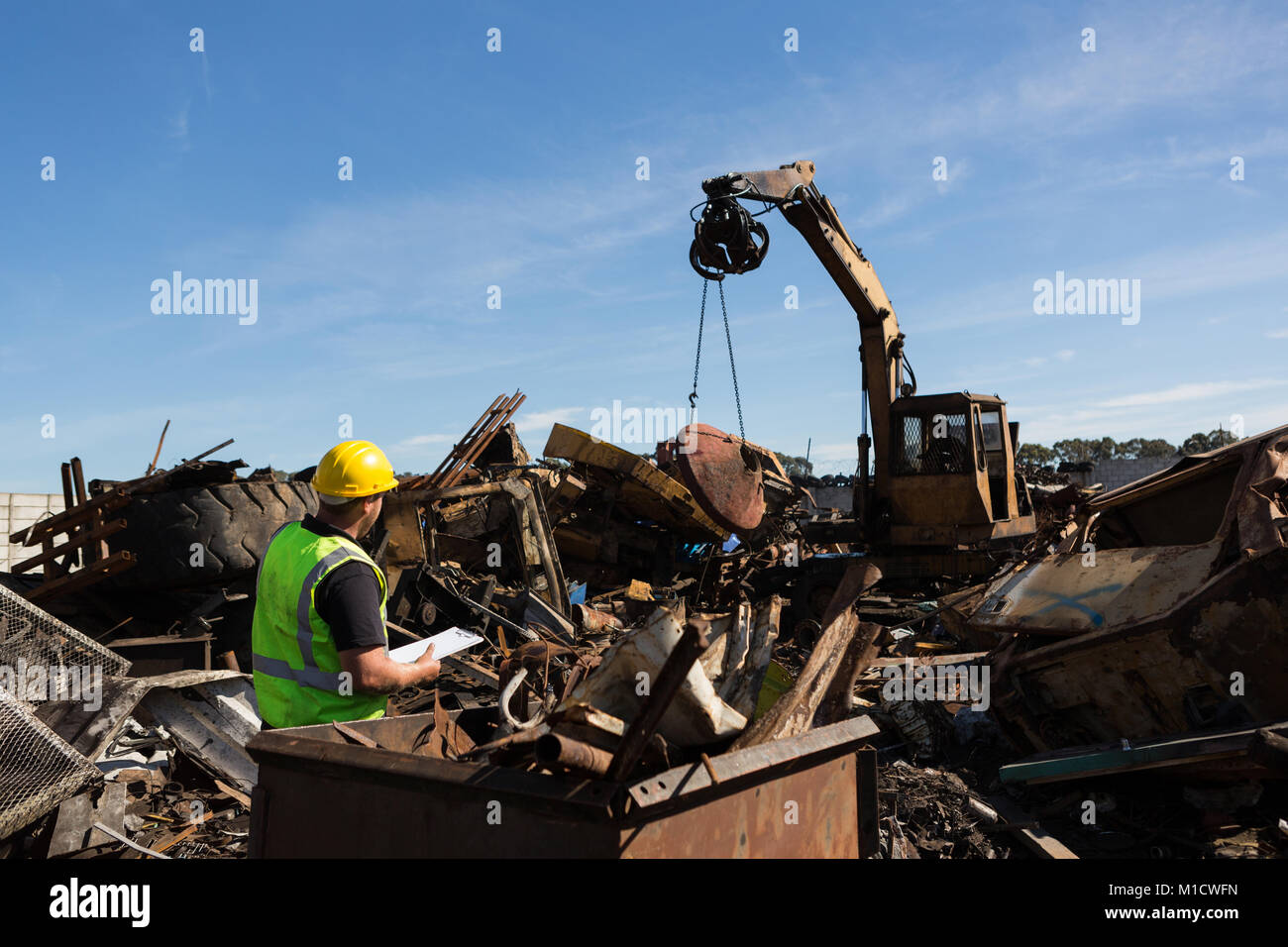 Monitoraggio dei lavoratori il thrash essendo sollevata con una gru Foto Stock