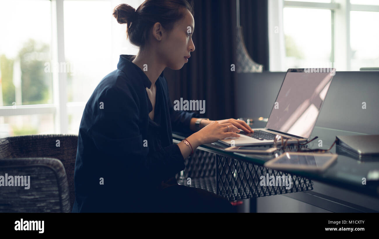Bella donna utilizzando laptop a tavola Foto Stock