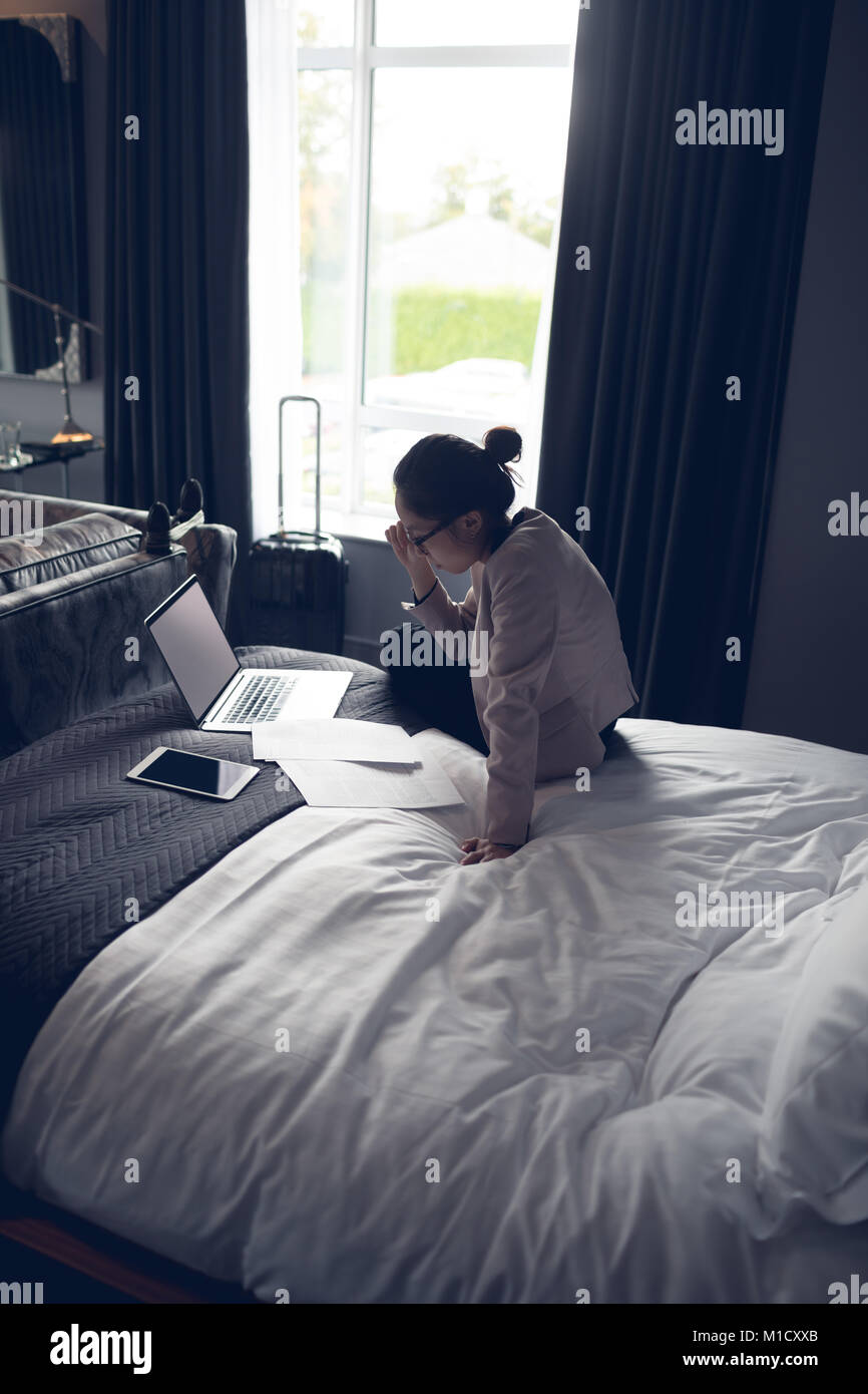 Bella donna utilizzando laptop sul letto Foto Stock