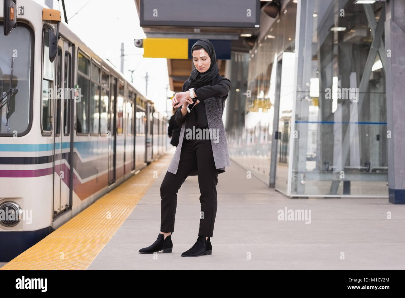 Donna in hijab utilizzando smartwatch Foto Stock