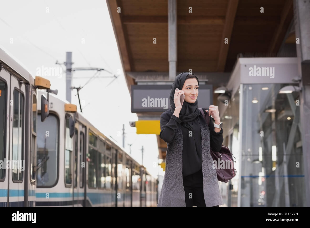 Donna in hijab parlando al telefono cellulare Foto Stock