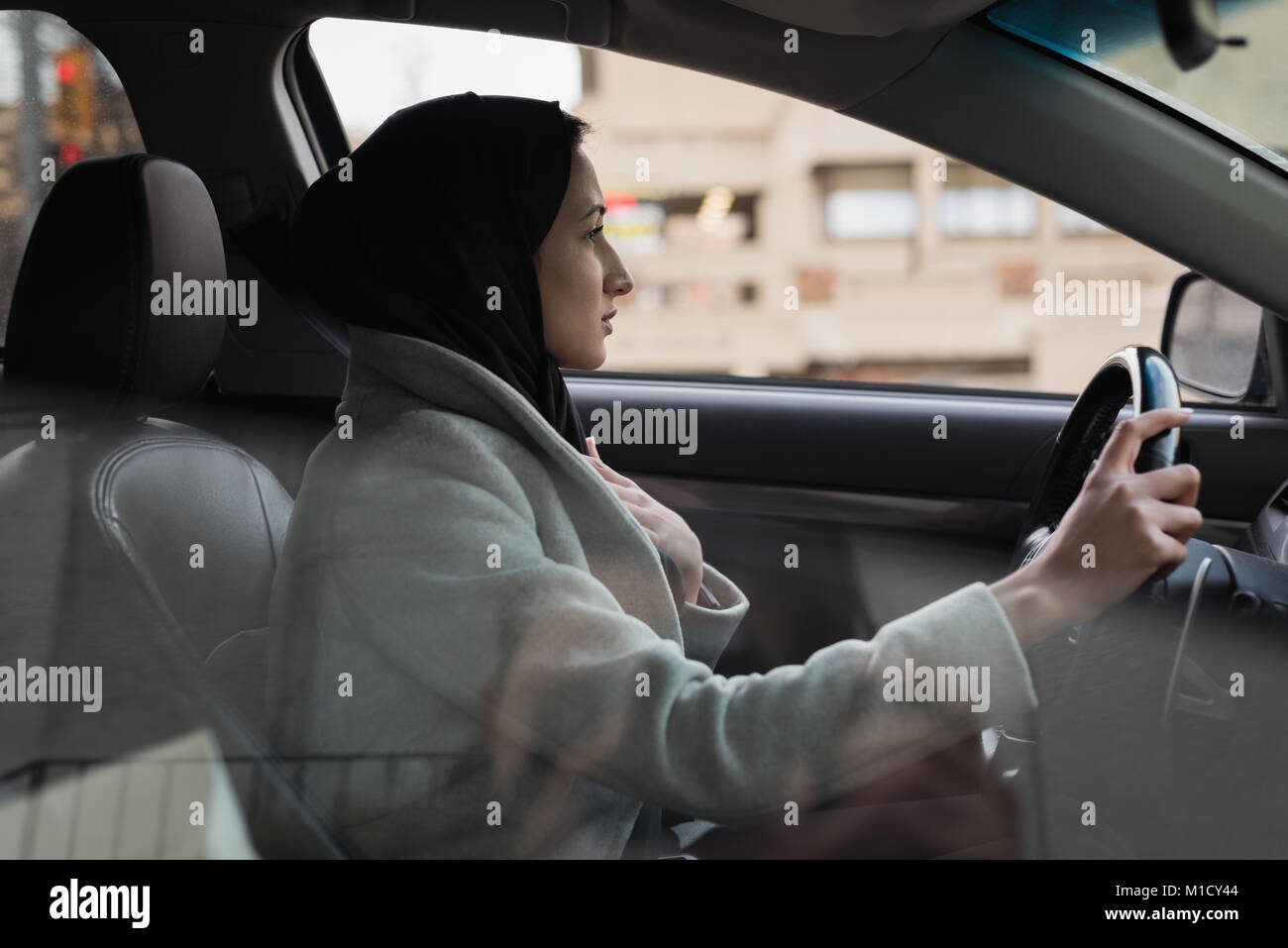 Donna in hijab è alla guida di un veicolo Foto Stock