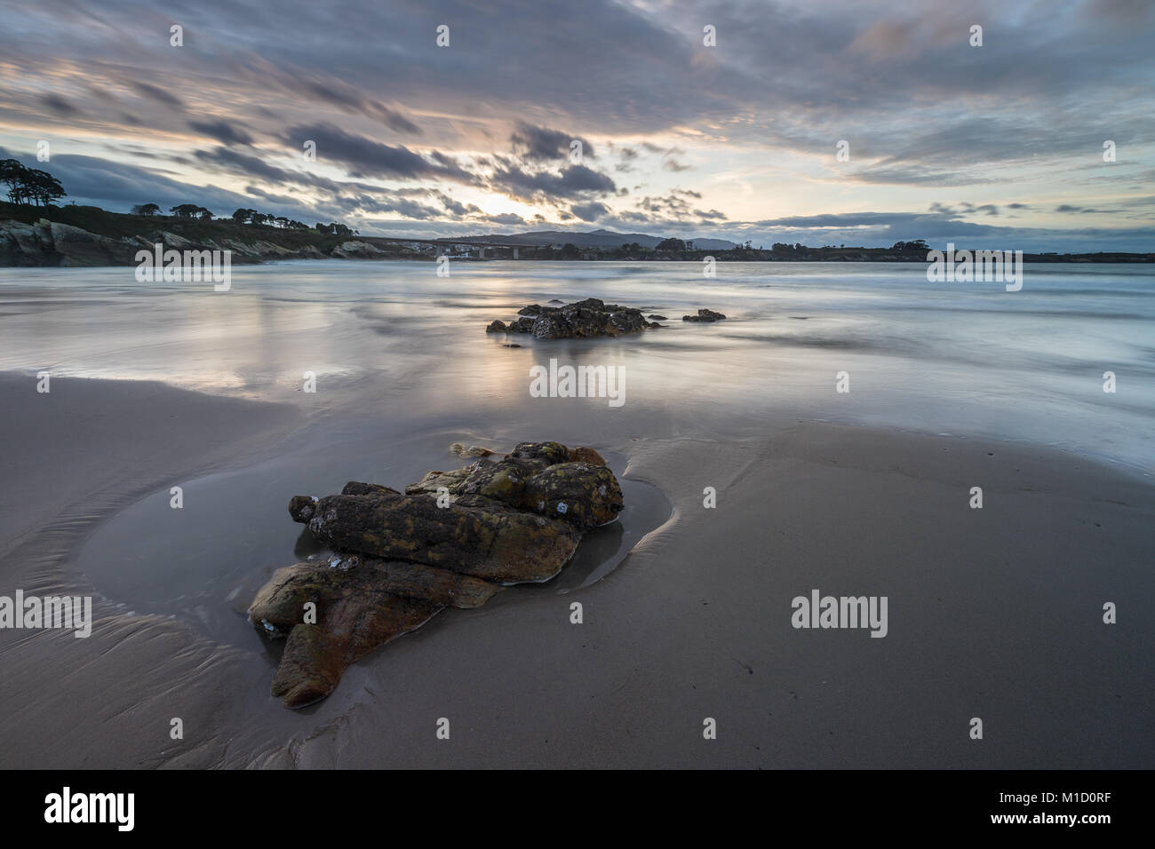 Un tramonto spettacolare sulla spiaggia di Arnao, Asturias, fotografando i diversi colori, forme e texture delle nuvole, riflessa nella sabbia fine Foto Stock