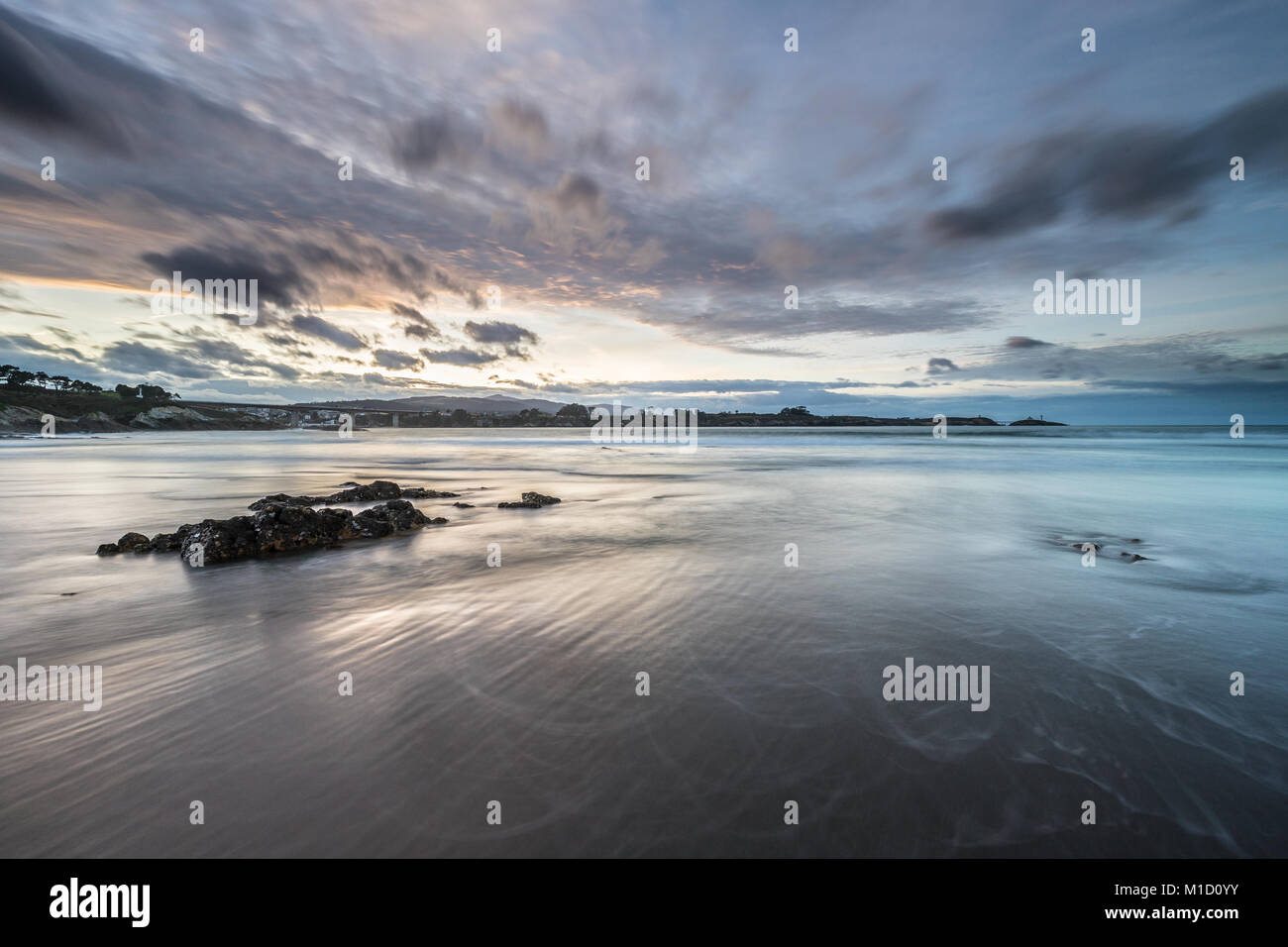 Un tramonto spettacolare sulla spiaggia di Arnao, Asturias, fotografando i diversi colori, forme e texture delle nuvole, riflessa nella sabbia fine Foto Stock