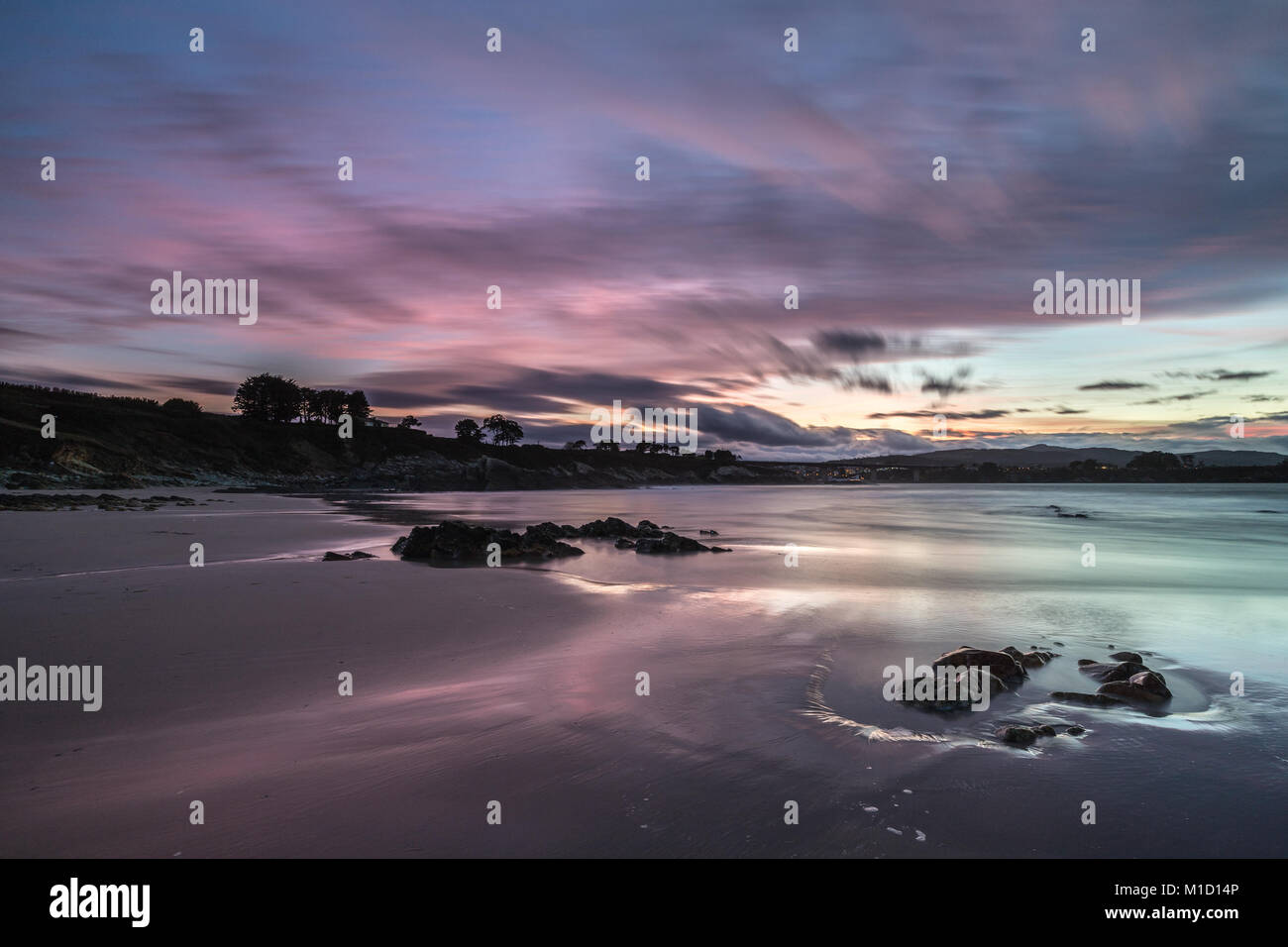 Un tramonto spettacolare sulla spiaggia di Arnao, Asturias, fotografando i diversi colori, forme e texture delle nuvole, riflessa nella sabbia fine Foto Stock