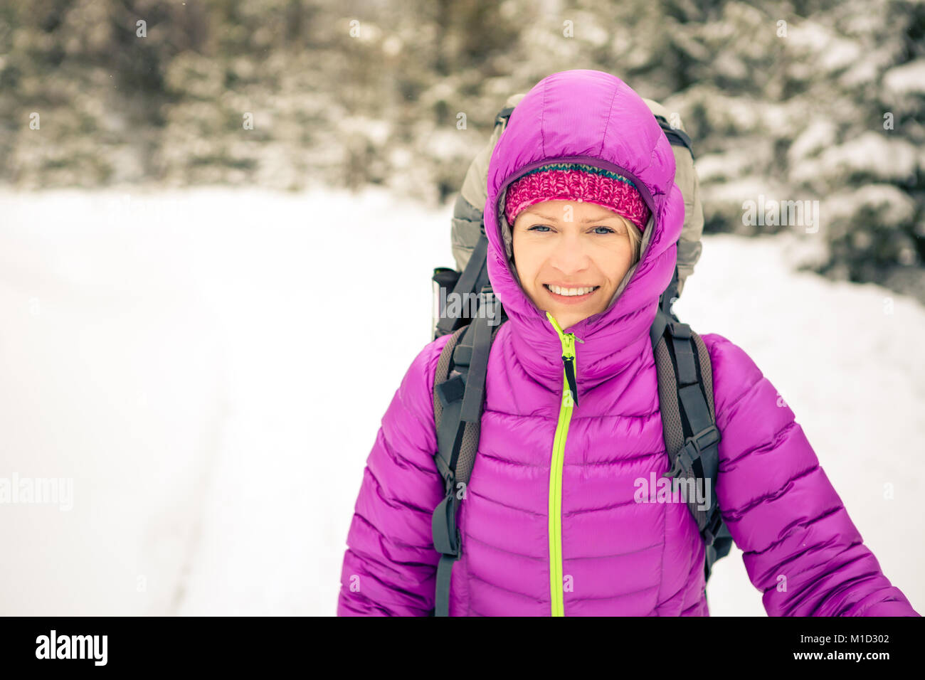 Donna escursionismo in bianco inverno boschi della Foresta con zaino. Giovane ragazza camminare sul sentiero innevato. La ricreazione del fitness e uno stile di vita sano, camping all'aperto Foto Stock