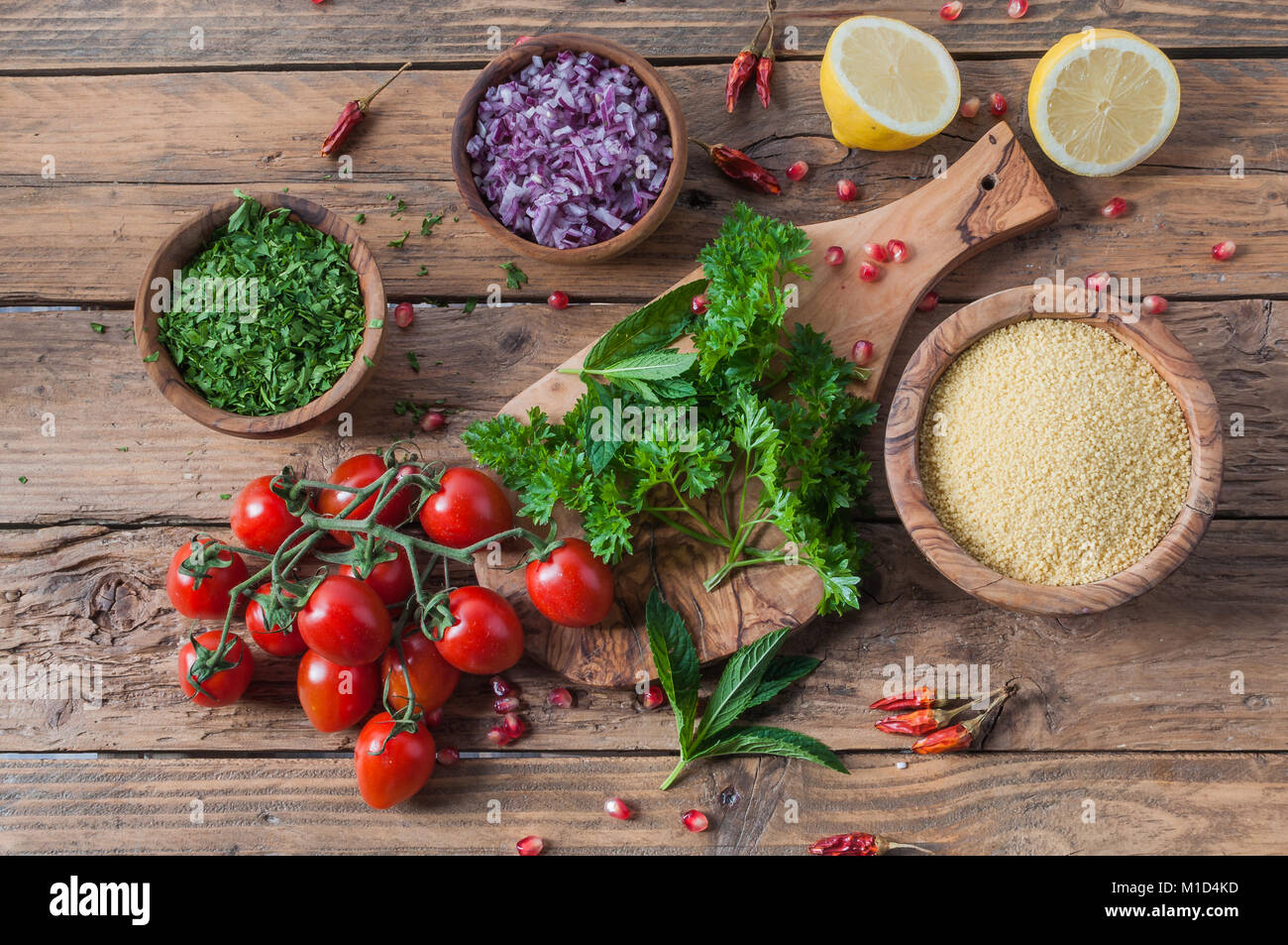 Materie prime e ingredienti per insalata tabulé su tavola in legno rustico Foto Stock