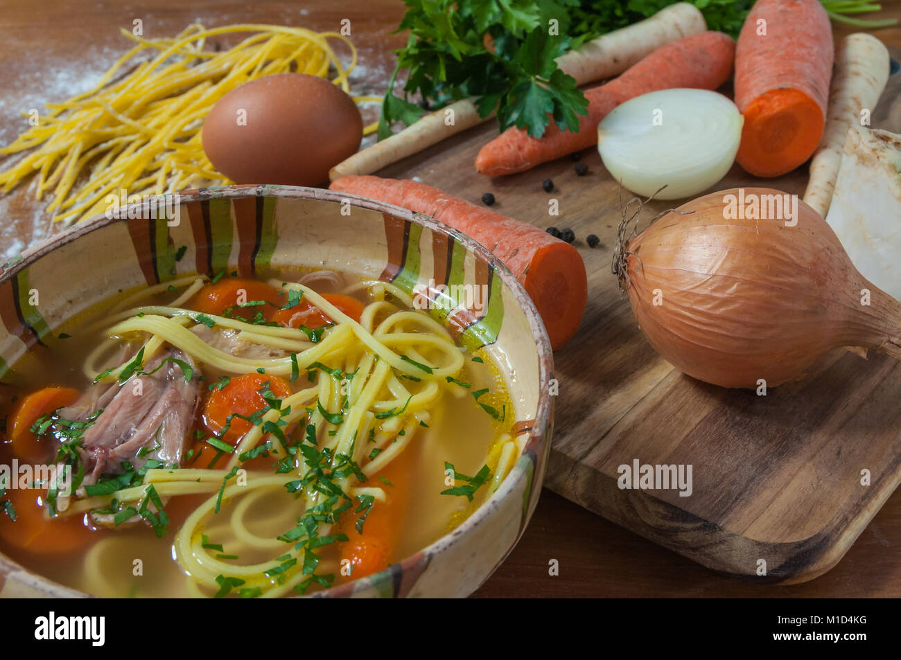 Zuppa di pollo in una ciotola rustico e gli ingredienti sul tavolo di legno Foto Stock