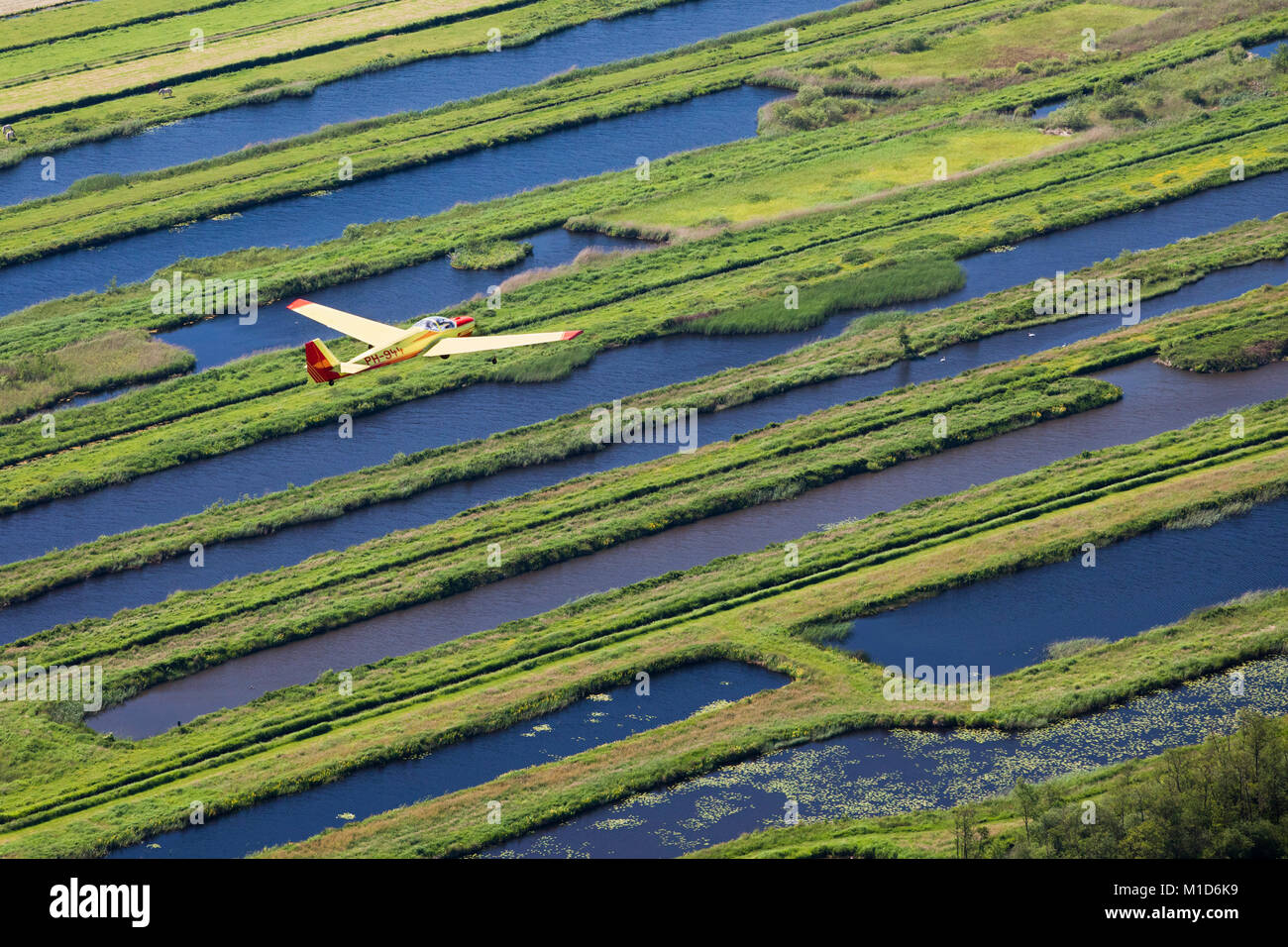 I Paesi Bassi, Loosdrecht, piccoli aeromobili battenti su acqua stagni, ex paesaggio di torba. Antenna. Foto Stock