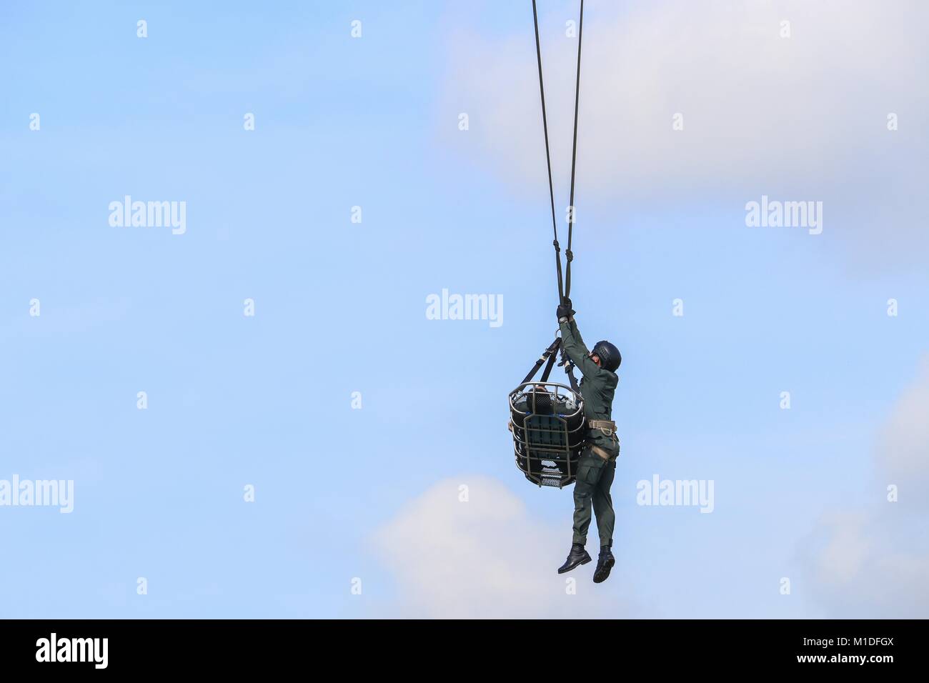 Soldato di emergenza soccorso dall esercito elicottero con fune sul cielo blu Foto Stock