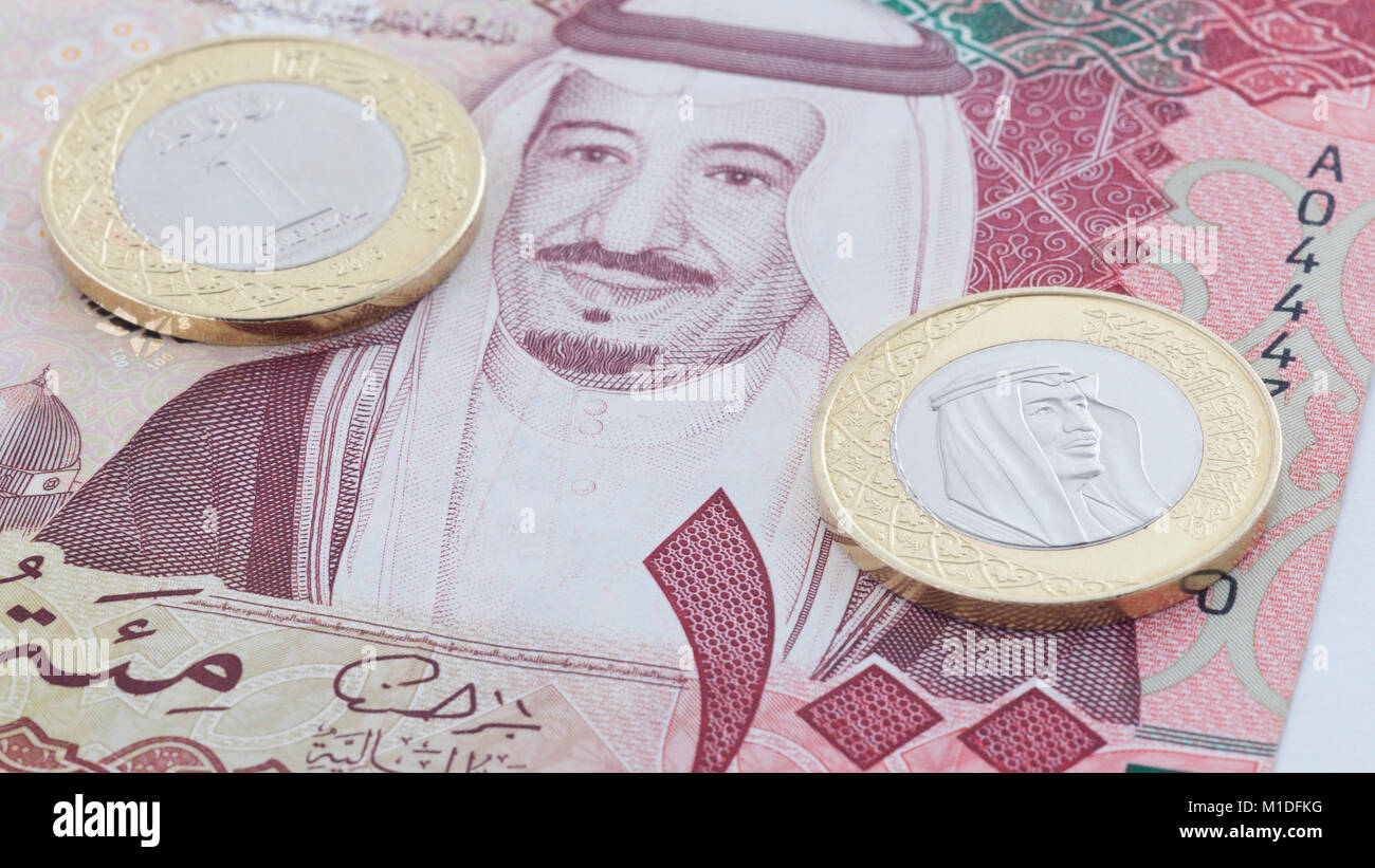Saudi Riyal 100 delle banconote e delle nuove monete che mostra re Salman di Arabia Saudita Foto Stock