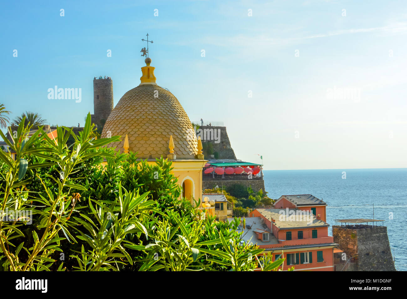 Il turista a godere di una bellissima vista del mare ligure presso il villaggio di Vernazza Italia, parte delle Cinque Terre, con la Chiesa di Santa Margherita chiesa duomo Foto Stock