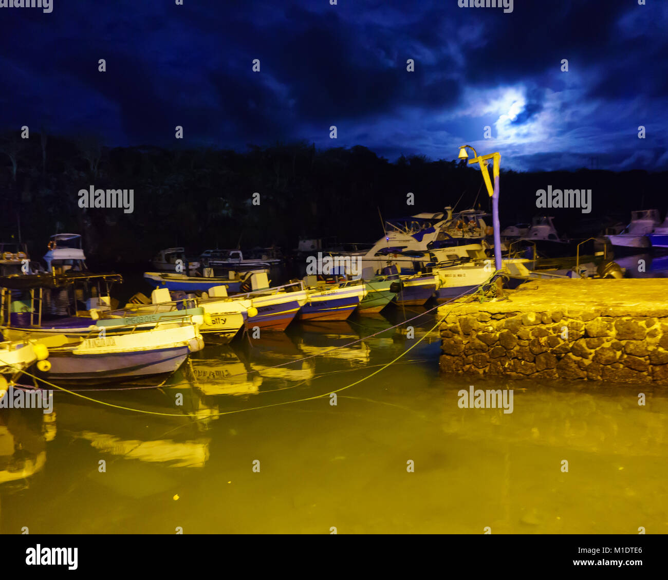 Barche di pescatori alleggerire la luna nel porto di Santa Cruz isola la mattina presto (Galapagos) Foto Stock