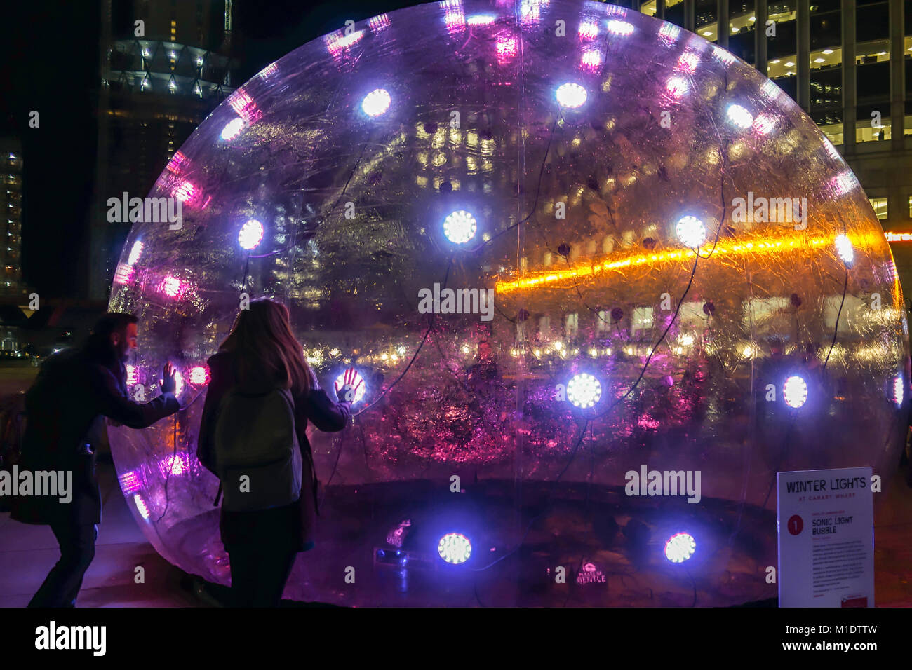 Londra, UK-25 JAN 2018: un giovane interagisce con la luce di Sonic bolla mediante ENESS al Giubileo Plaza per il Canary Wharf invernale del Festival delle Luci 2018. Foto Stock