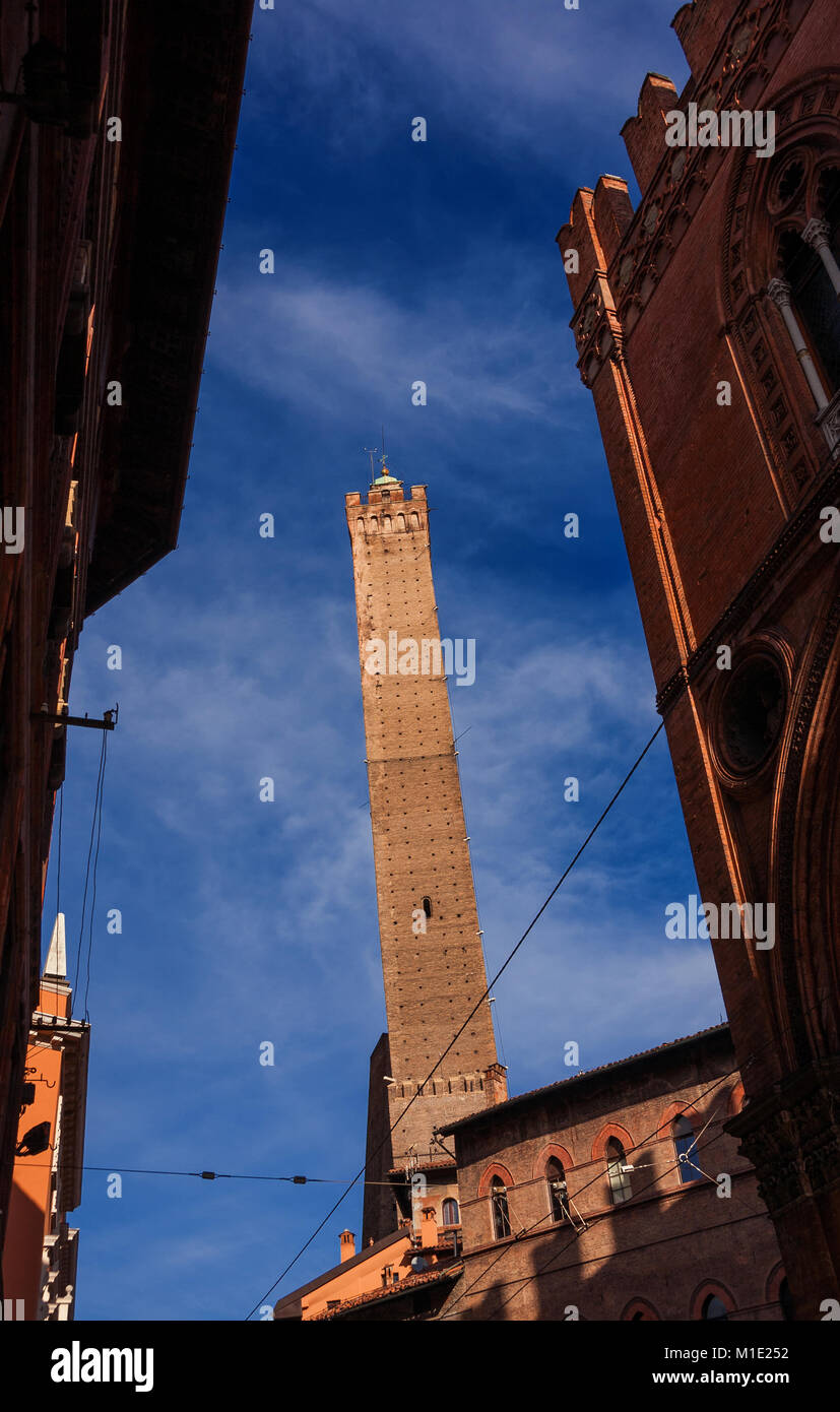 Inclinazione medievale Torre degli Asinelli, la piu' alta torre in Bologna e il simbolo della città, eretto alla fine del XII secolo, visto da una stretta s Foto Stock