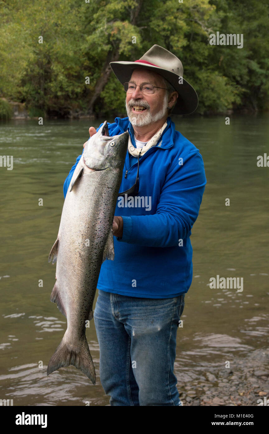 Masterizzatore esterno Terry Sheely con un luminoso Salmone Chinook, catturato sulla Klickitat,fiume, nello Stato di Washington, Foto Stock