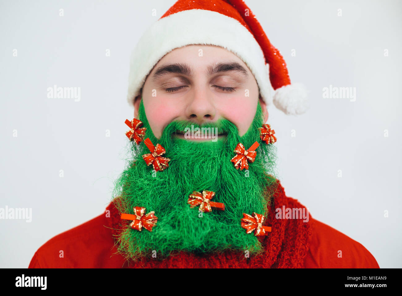 Babbo Natale in rosso vestiti con barba verde decorato con archi rossi come un albero di natale Foto Stock