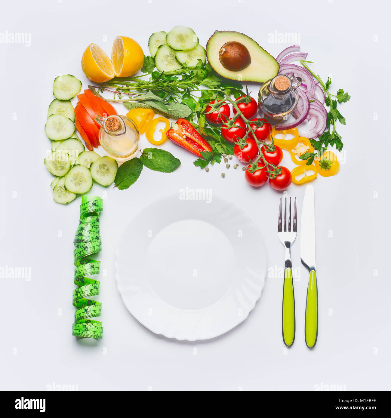 Pulire sano di mangiare o dieta alimenti concetto. Varie insalate con piastra bianca , posate verde e nastro di misurazione su sfondo bianco, vista dall'alto, Foto Stock