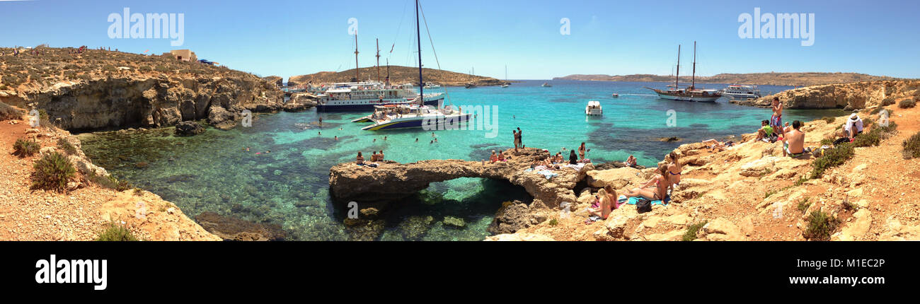 Alla Laguna Blu di Comino isola al largo della costa di Malta, qui le barche turistiche si fermano per consentire ai passeggeri di nuotare nel mare azzurro. Foto Stock