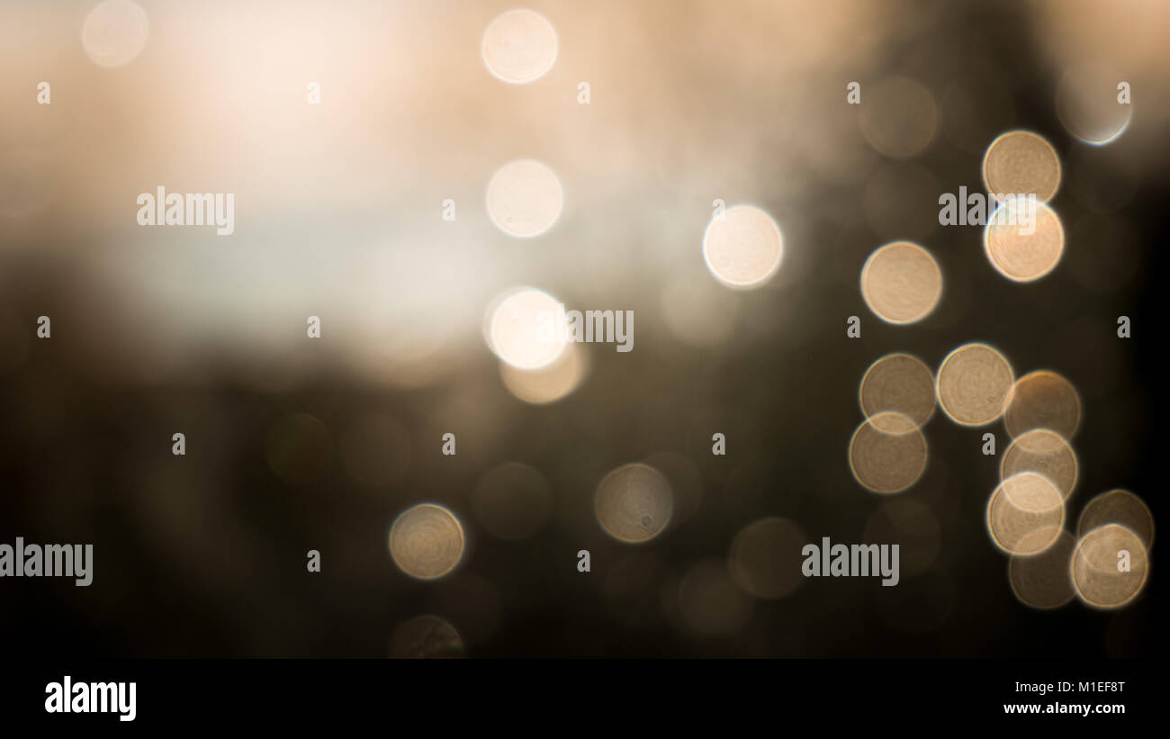 Bokeh di fondo per effetto delle gocce di pioggia su una finestra. Color seppia per dare ad esso un aspetto festoso. Foto Stock