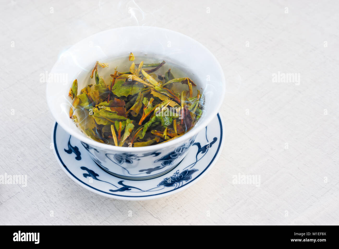 Bianco tradizionale tè cinese con la peonia bianco sul tavolo bianco, lo spazio di testo Foto Stock