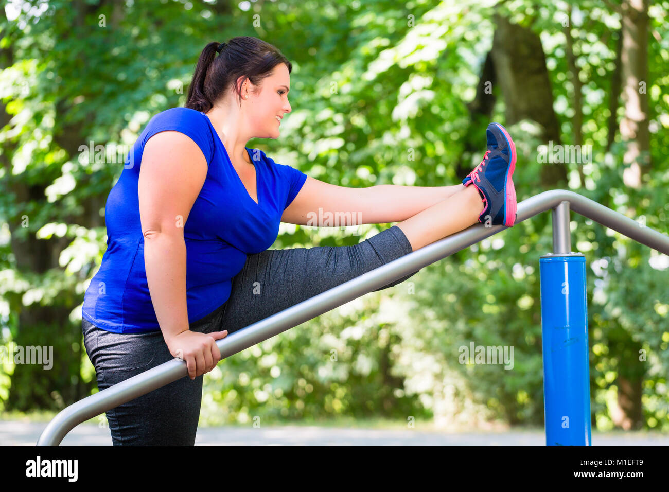 Donna obesa facendo stretching sport all'aperto nel parco Foto Stock