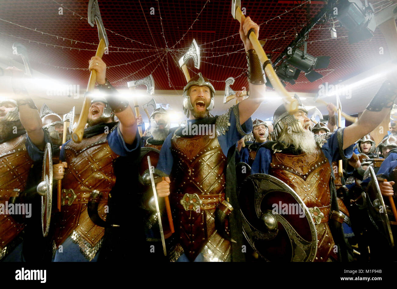 I membri della squadra Jarl vestito in abiti Viking cantare il Royal British Legion Club prima di marciare attraverso le strade a Lerwick sulle Isole Shetland durante la Up Helly Aa Viking Festival. Foto Stock