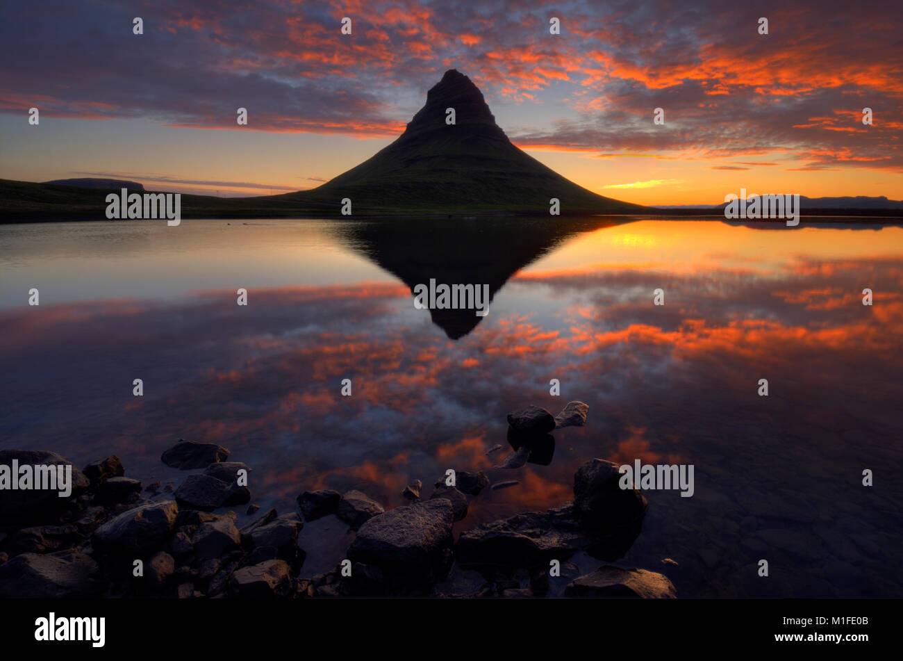 Il sole di mezzanotte a Kirkjufellsfoss, Islanda Foto Stock