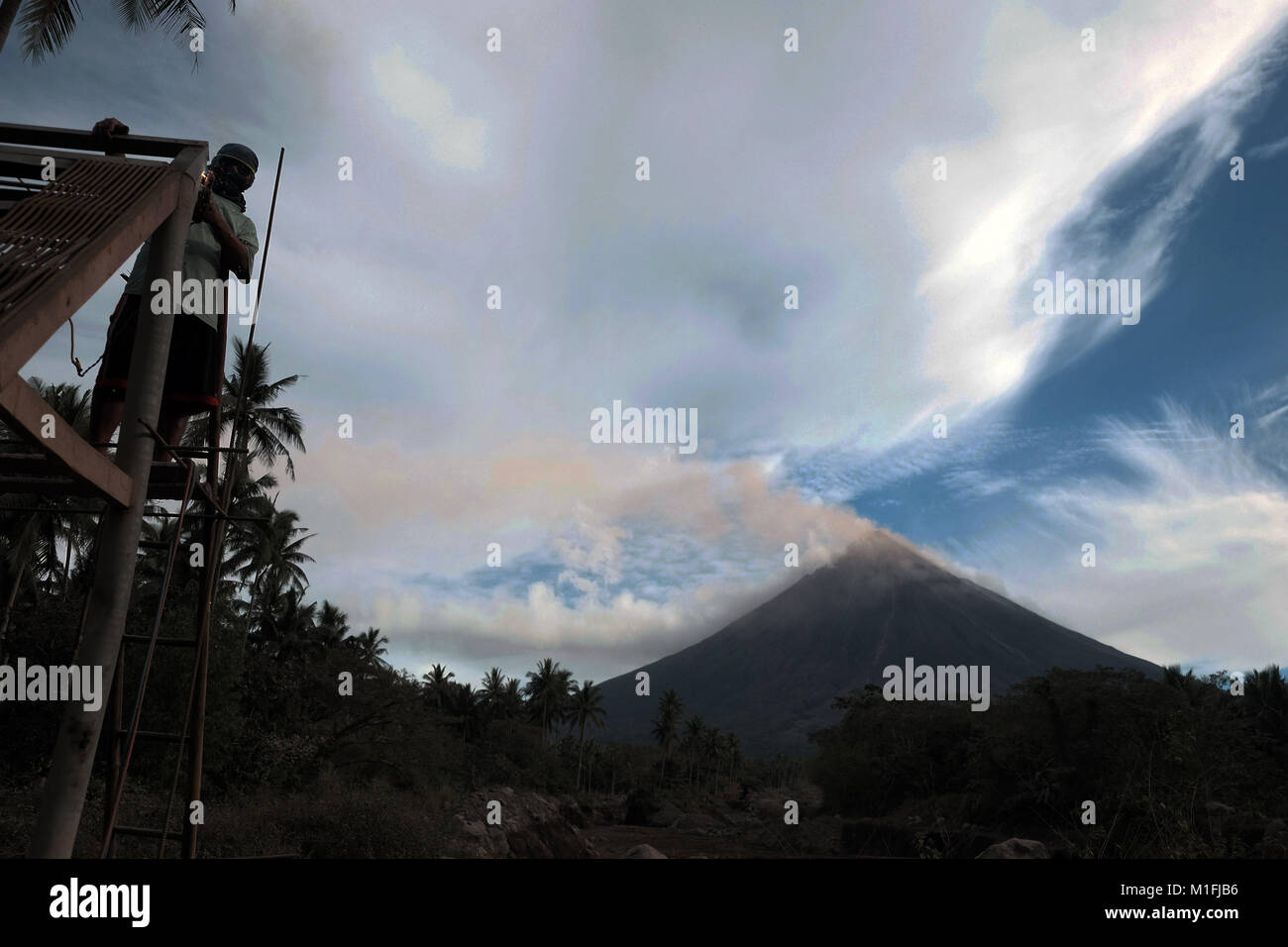 25 gennaio 2018 - Guinobatan, Albay, regione di Bicol, Filippine - Mt. Mayon fuoriesce cenere lavoratore mentre esegue il suo lavoro regolare..Il vulcano Mayon eruzione ha realizzato decine di migliaia di residenti locali di dover lasciare la loro casa per rimanere nel governo fornito rifugi temporanei. L'ultima grande eruzione del vulcano Mayon è stato registrato nel 2013. (Credito Immagine: © Romeo Mariano/SOPA via ZUMA filo) Foto Stock