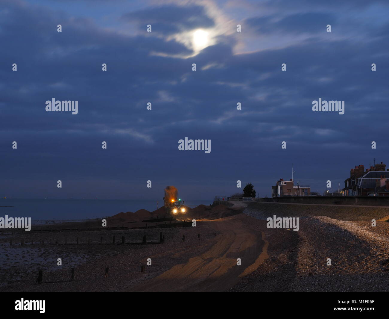 Sheerness, Kent, Regno Unito. 30 gen, 2018. Agenzia per l'ambiente gli appaltatori lavorano al chiaro di luna per mantenere le difese del mare in Sheerness. Team Van Oord sono lo scavo di circa 15.000 metri cubi di ghiaia dal punto di guarnigione di rifornire la spiaggia a est. Appaltatori lavorano dalle 6 am alle 22.00 durante la bassa marea e spero di riuscire a completare il lavoro entro la fine del mese di febbraio. Credito: James Bell/Alamy Live News Foto Stock