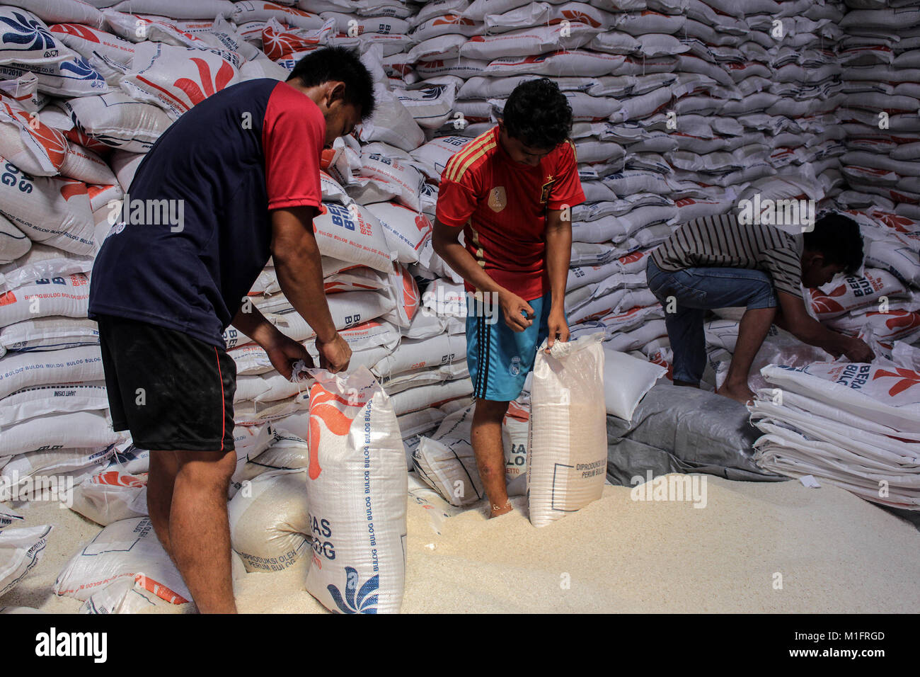 Lhokseumawe, Aceh, Indonesia. 30 gen, 2018. Lavoratori visto il riempimento della confezione di riso al Bulog Lhokseumawe magazzino e il riso stanno per essere distribuiti alle famiglie bisognose. Il governo indonesiano distribuisce gratuitamente il riso per dieci milioni di famiglie beneficiarie (KPM), per un totale di dieci chilogrammi al mese a tutte le parti dell'Indonesia. Credito: Maskur ha/SOPA/ZUMA filo/Alamy Live News Foto Stock