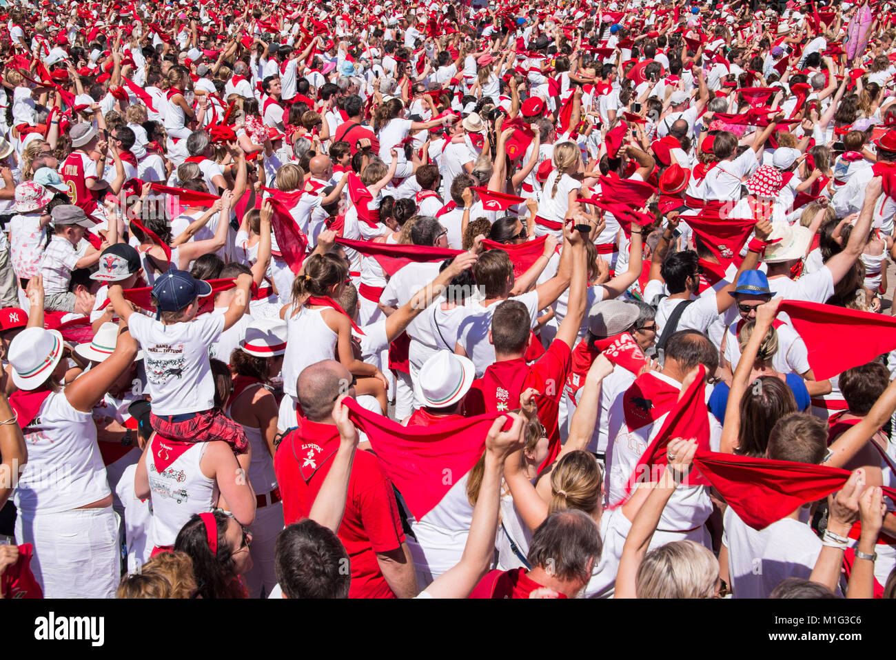 La folla di persone vestite di bianco e rosso al festival estivo di Bayonne (Fetes de Bayonne), Francia Foto Stock