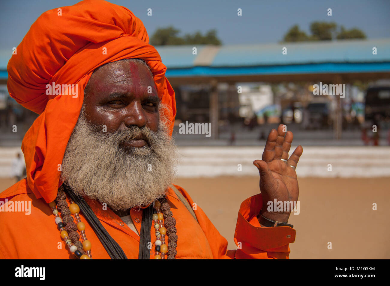 Hindu uomo santo, sadhu, con grande barba folta in arena centrale a Pushkar Camel Fair, Rajasthan, India Foto Stock