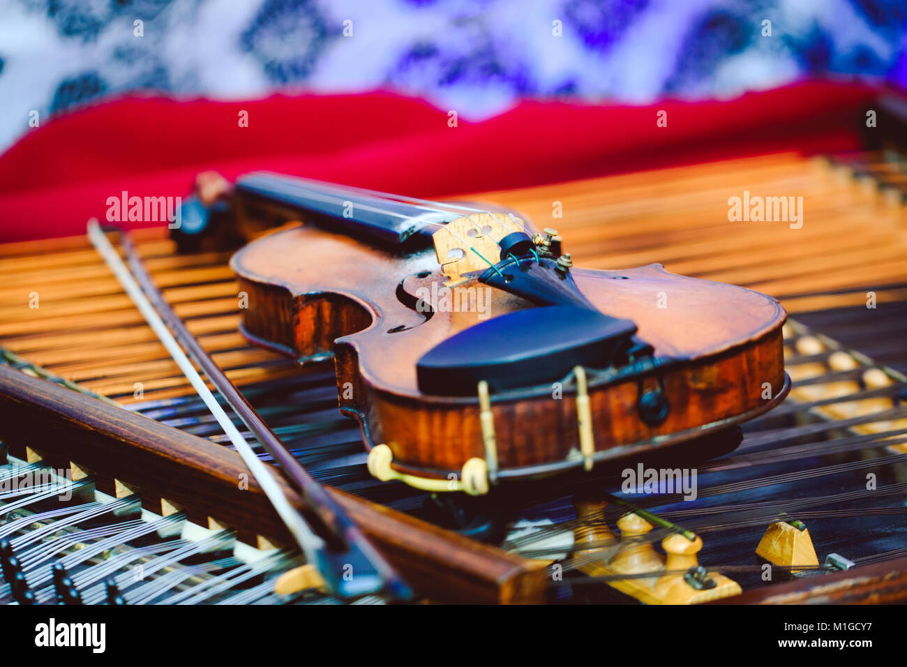 Violino in dettaglio sul piatto. Dulcimer e violino con bassa profondità di campo e la messa a fuoco selettiva sul ponte del violino Foto Stock