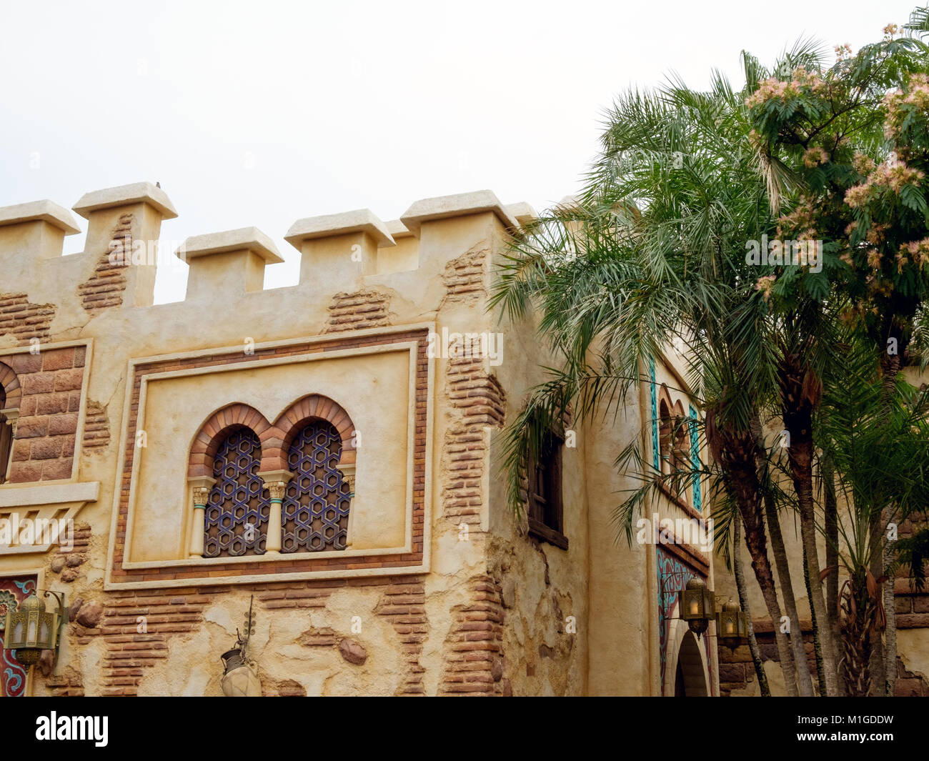 Palme sulla destra e rustico stile Arabo edificio con finestre ad arco. In Arabian Coast attrazione, Disney Sea, Tokyo. Foto Stock