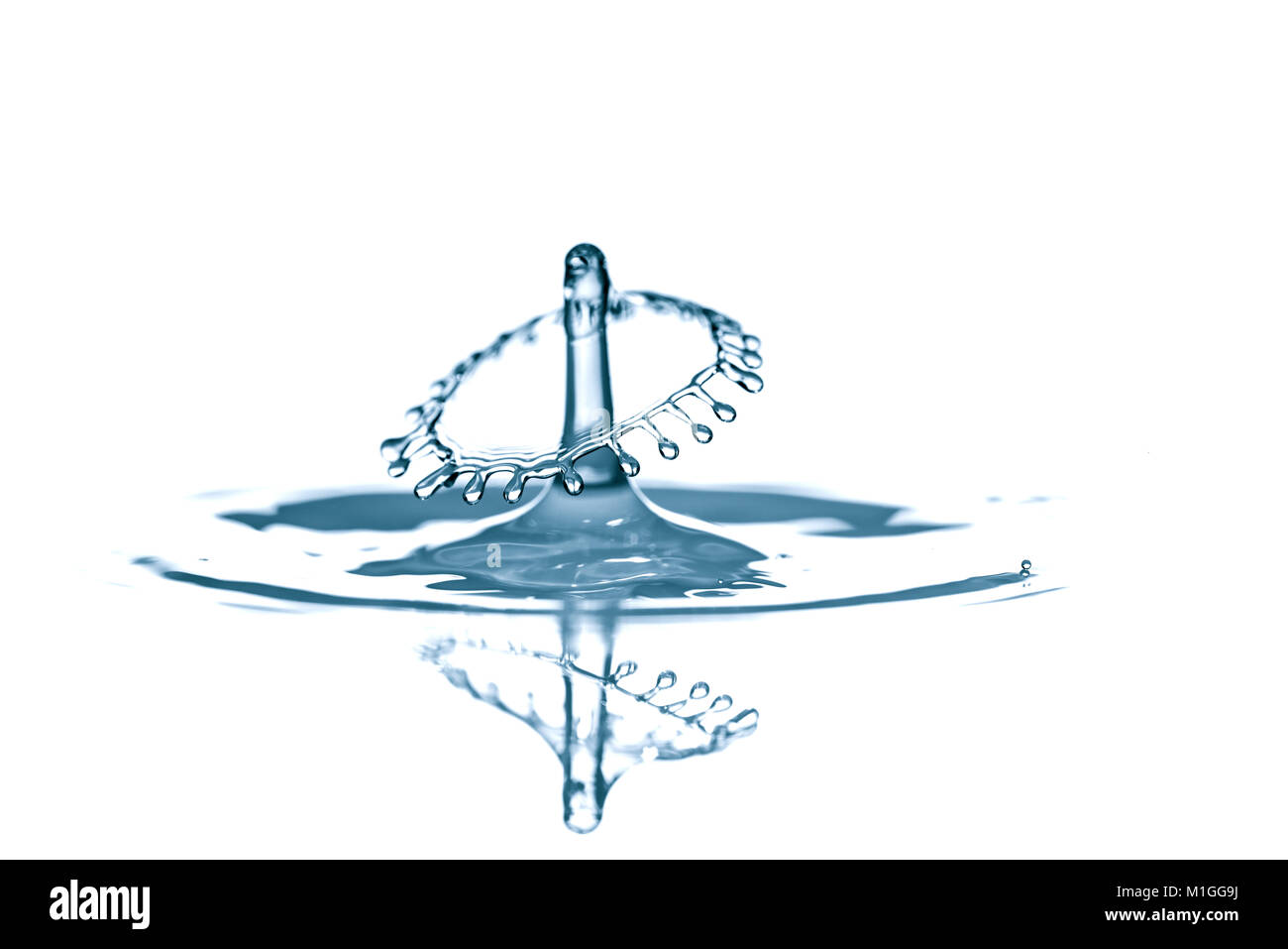 Splash e corona su increspato azzurro liquido o superficie di acqua . Spruzzi di acqua con una corona e di riflessione Foto Stock