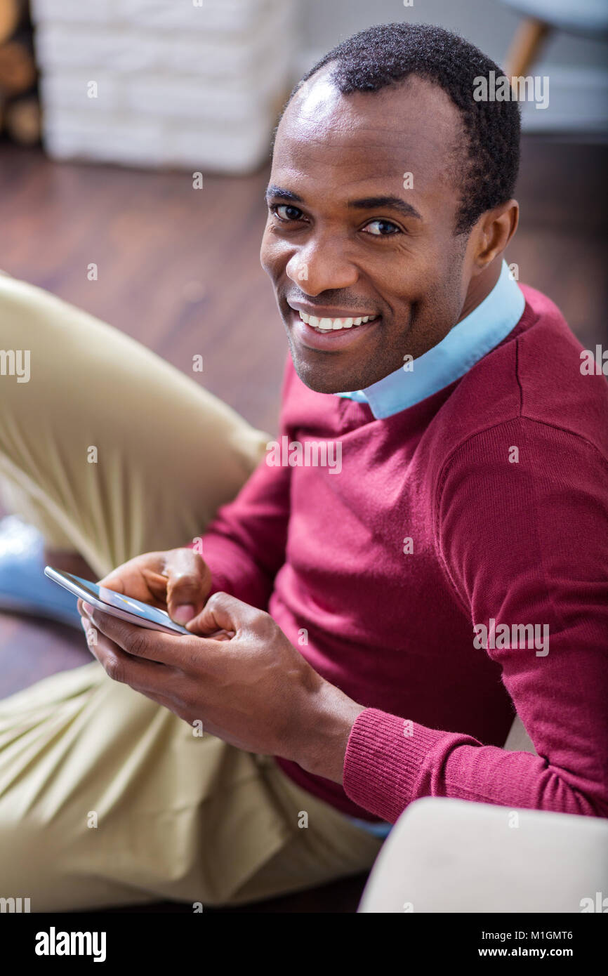 Allegro uomo bello con il suo dispositivo mobile Foto Stock