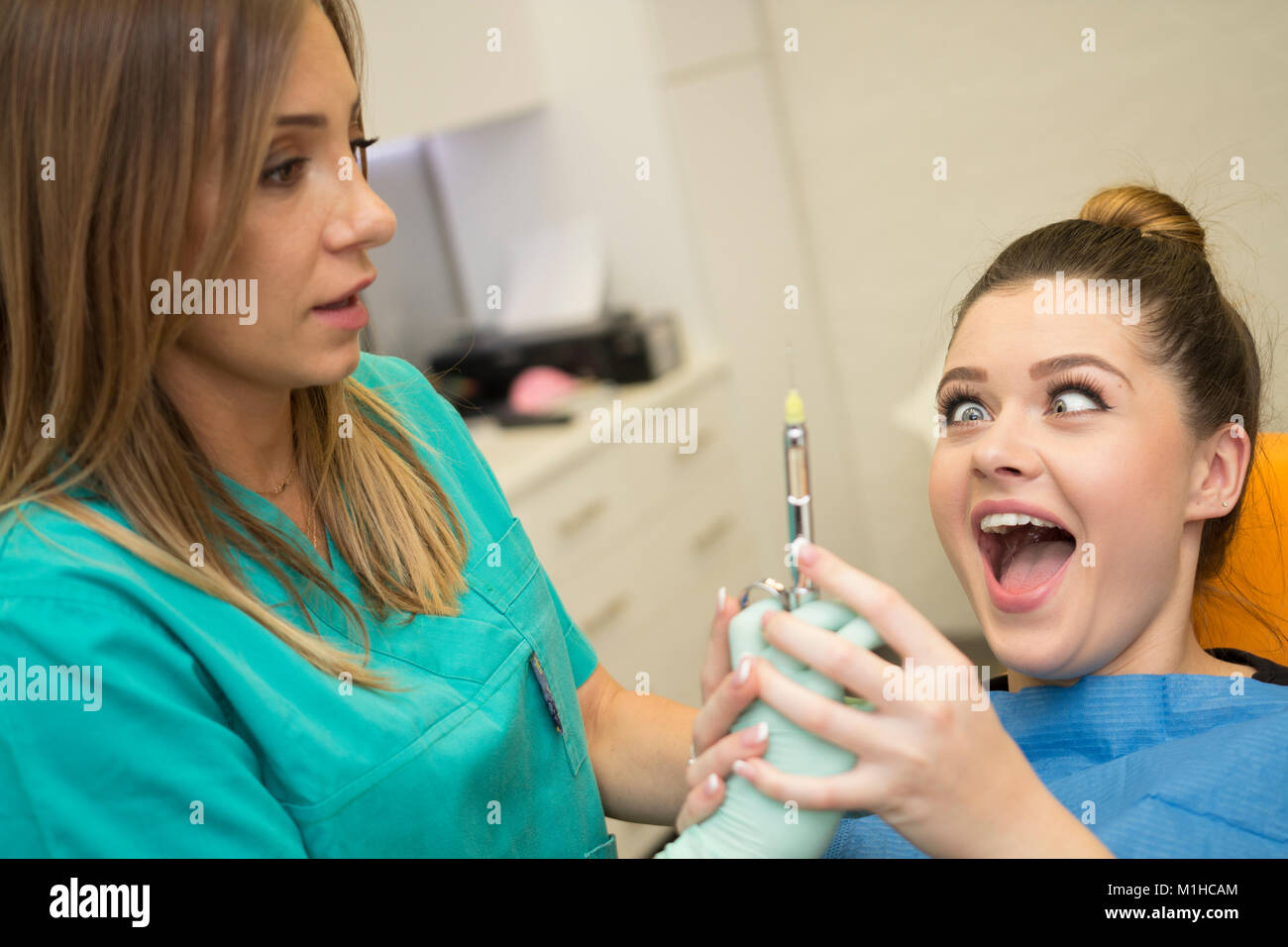 Un paziente ha paura del dentista e dell'ago l'anestesia proveniente da esso... Foto Stock