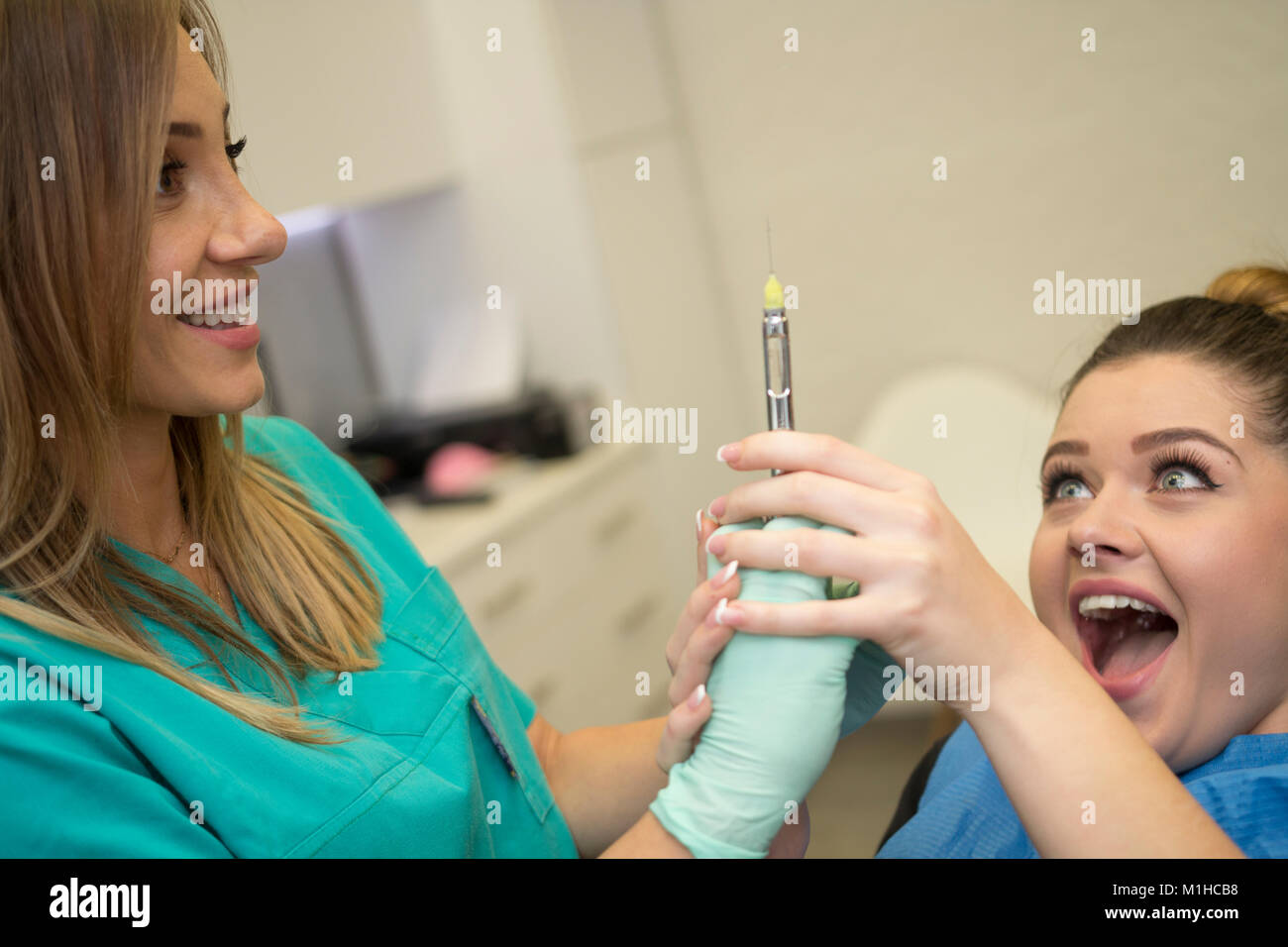 Un paziente ha paura del dentista e dell'ago l'anestesia proveniente da esso... Foto Stock