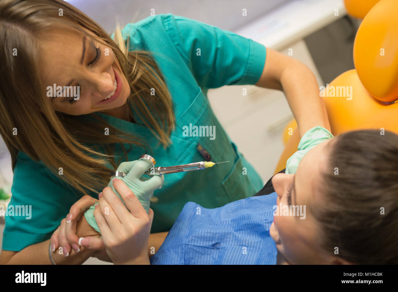 Un paziente ha paura del dentista e dell'ago l'anestesia proveniente da esso... Foto Stock