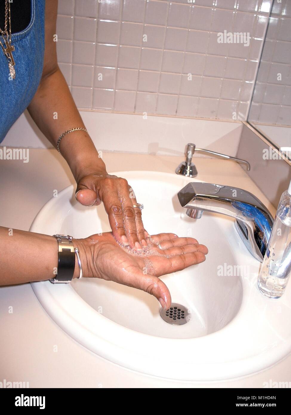 Una donna di lavarsi le mani dopo aver rimosso il vaiolo la vaccinazione bendaggio, close-up, all'restroom, presso i centri per il controllo delle malattie (CDC), Atlanta, Georgia, 2003. () Foto Stock