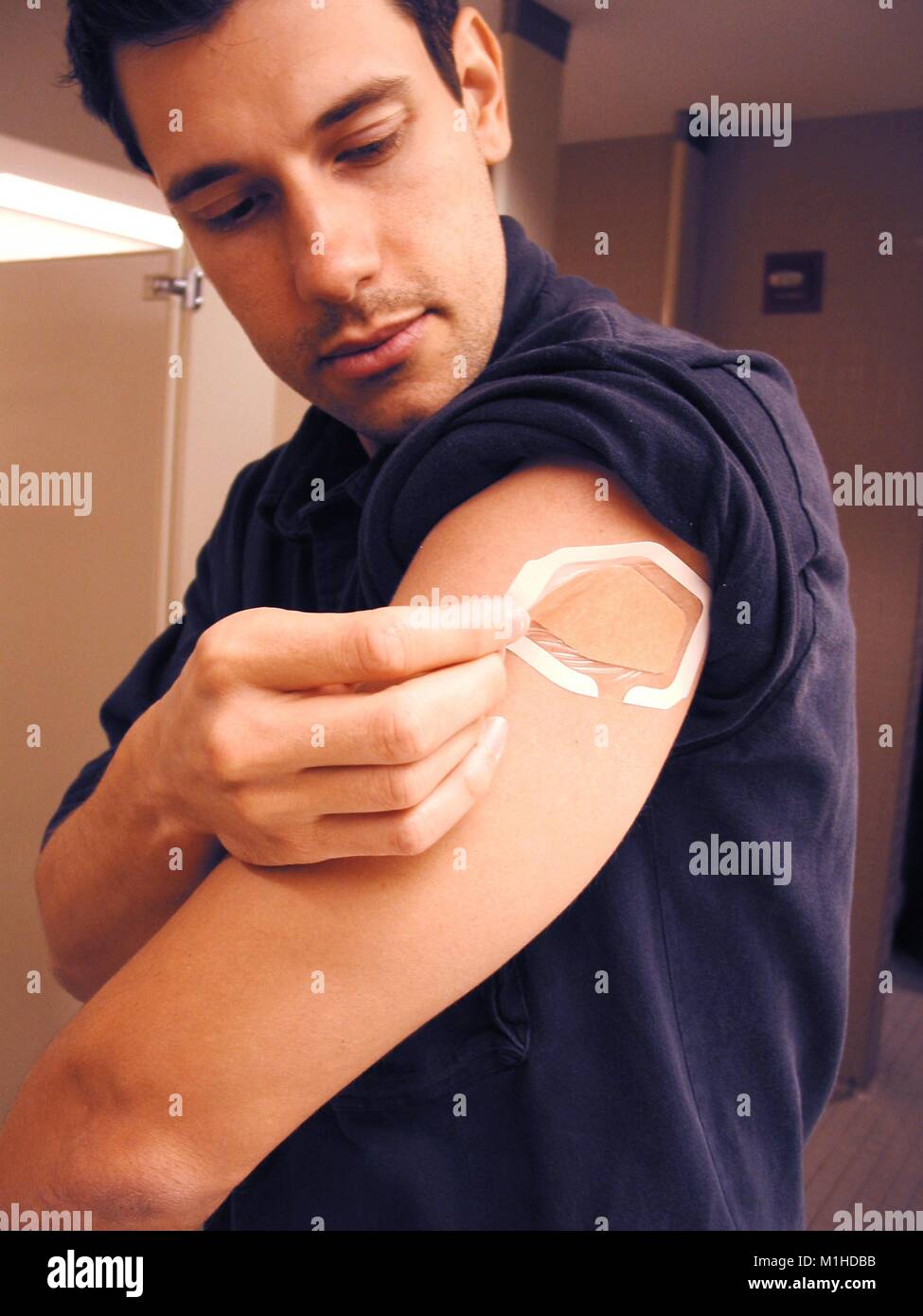 Un uomo avendo cura di vaiolo vaccino bendaggio dopo la vaccinazione, a restroom, presso i centri per il controllo delle malattie (CDC), Atlanta, Georgia, 2003. () Foto Stock