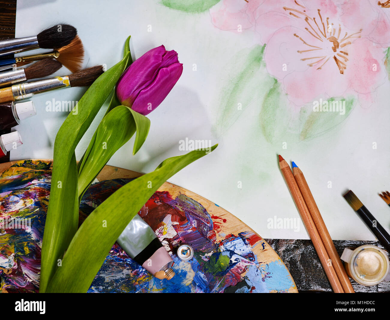 Autentica pennelli per dipingere la vita ancora sul tavolo in arte scuola  di classe. Gruppo di pennello e la tavolozza dei colori su un tavolo di  legno. Fiore come simbolo della molla