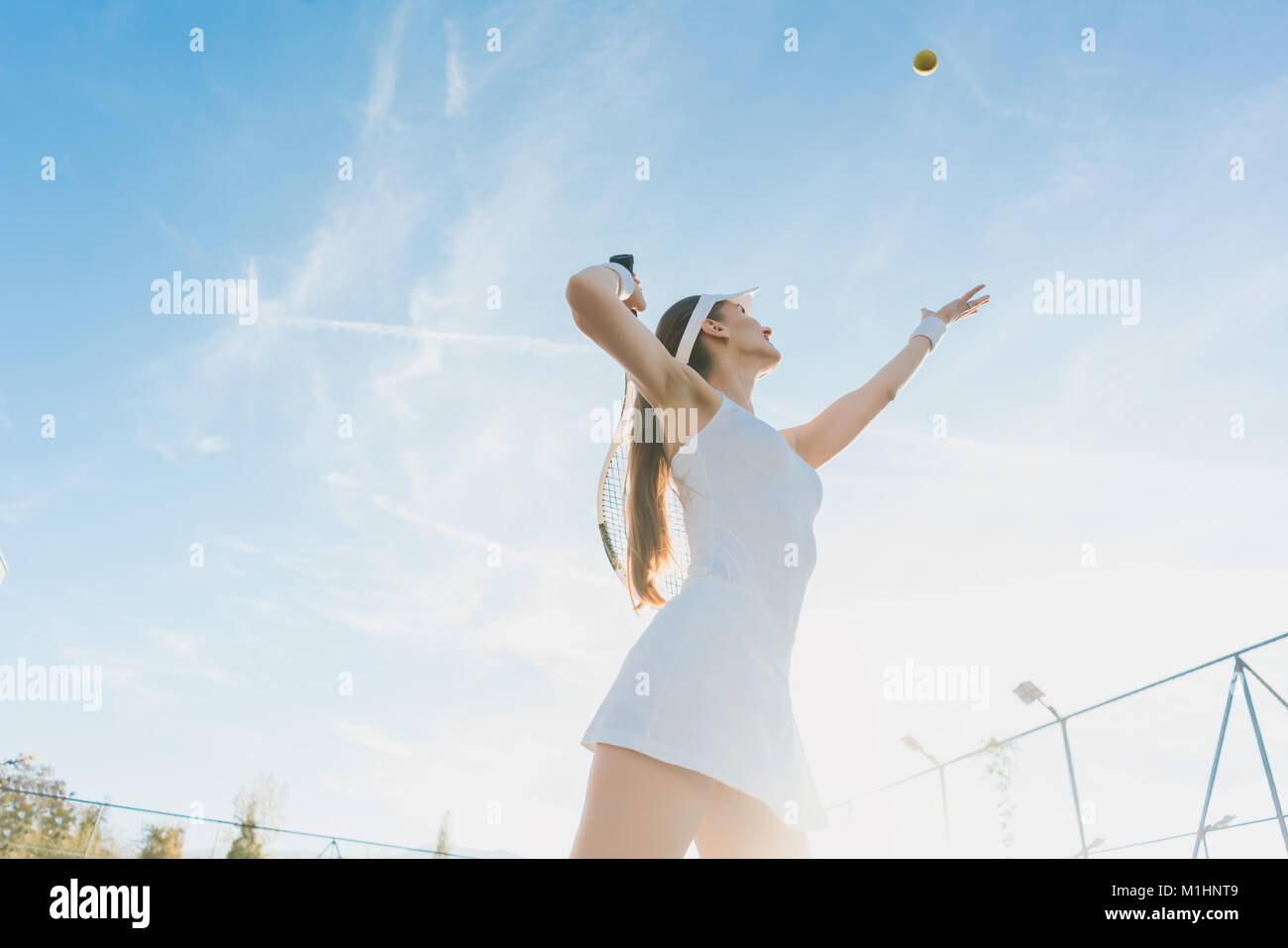 Donna che serve la sfera per un gioco di tennis Foto Stock