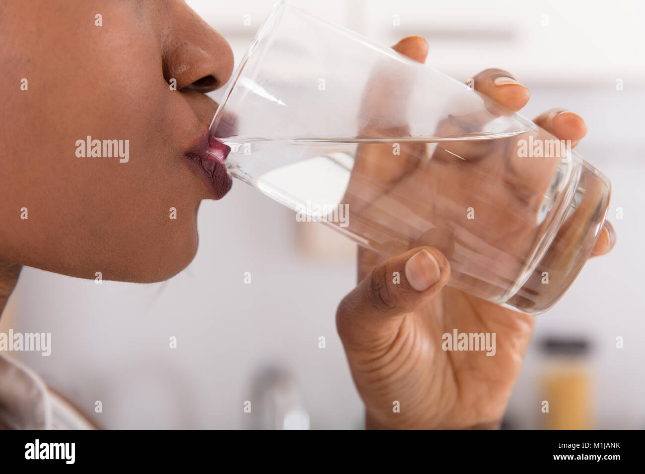 Close-up di una donna di mano di bere un bicchiere di acqua Foto Stock