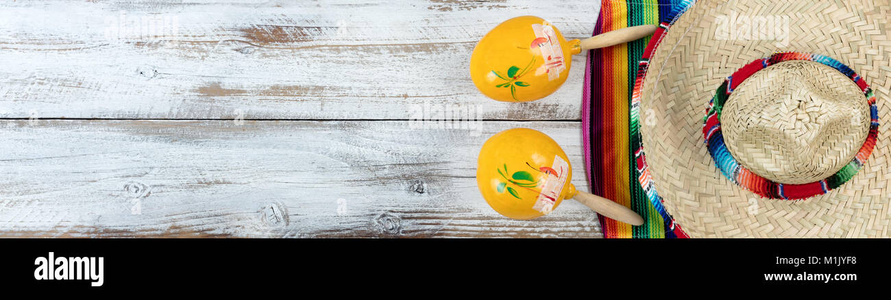 Tradizionale, le maracas e sombrero Serape messicano per il Cinco de Mayo holiday festa sul bianco spiovente di tavole di legno Foto Stock